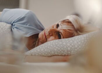 pensive senior woman lying bed thinking something